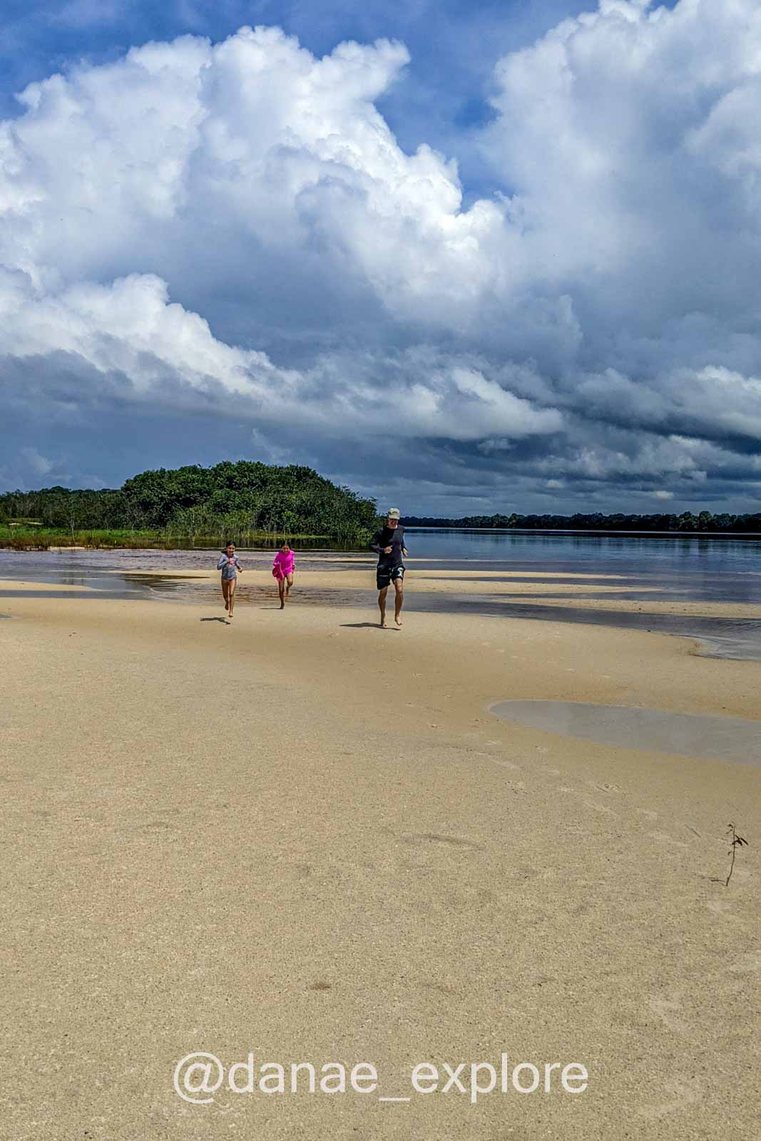 Crianças correndo em praia no Rio Negro, Amazônia, em dia nublado