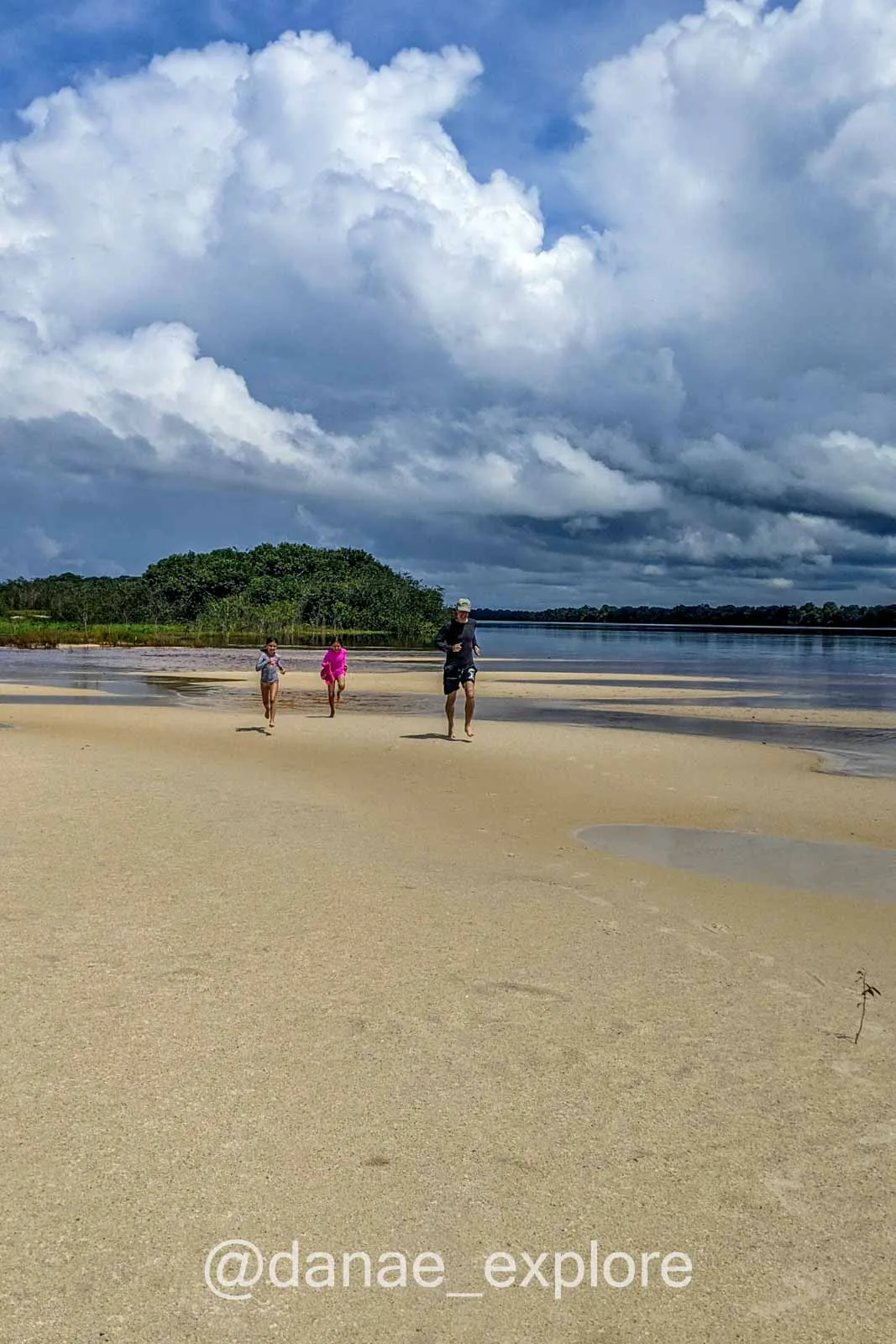 Children running on the beach in Rio Negro, Amazon, on a cloudy day