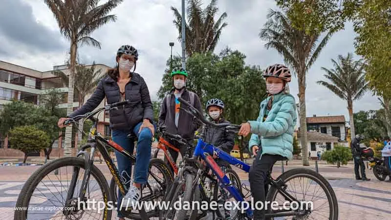 Familia de 4 pessoas em passeio de bicileta em Bogota, num dia nublado