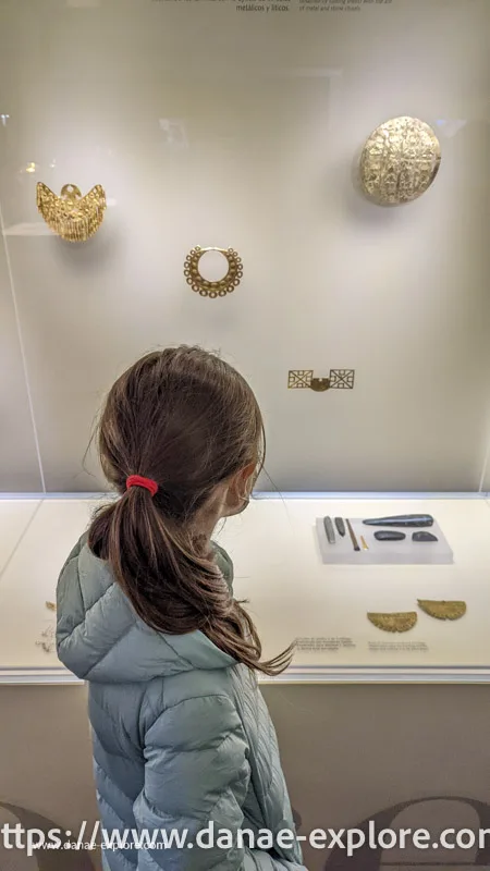 Menina olhando artefatos no Museo del Oro, Bogota