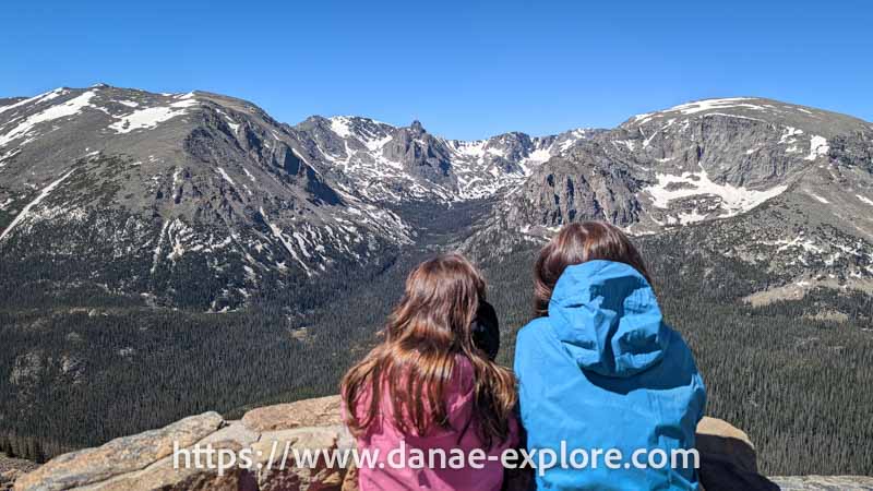 meninas observando montanhas com picos nevados na Trail Ridge Road, Parque Nacional das Montanhas Rochosas, Colorado