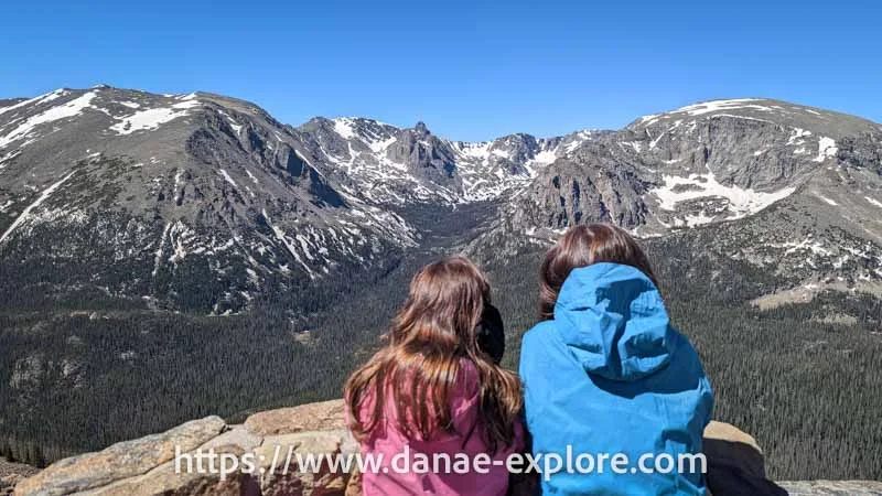 girls watching snow-capped mountains on Trail Ridge Road, Rocky Mountain National Park, Colorado
