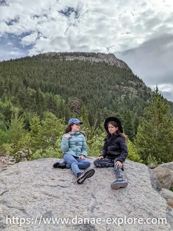 Two girls sitting at an overlook in Rocky Mountain National Park - trails in the Alberta Falls region
