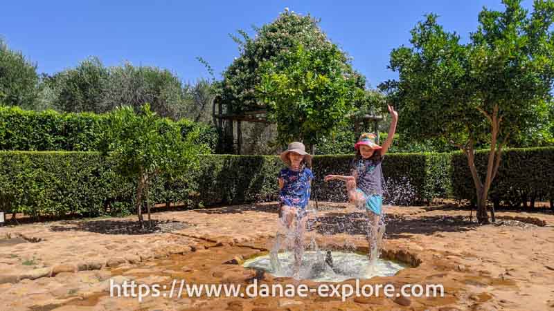 Crianças brincando e se refrescando na água, nos jardins da vinícola Babylonstoren, em Franschhoeck, Africa do Sul