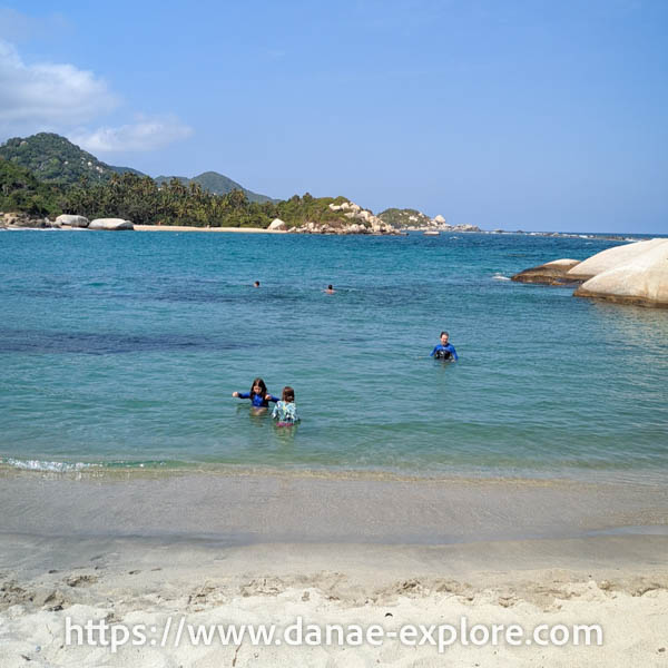 crianças brincando no mar azul turquesa. Praia La Arenilla, Parque Nacional Tayrona, Colômbia