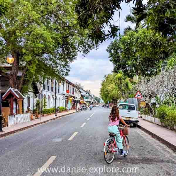 garota andando de bicicleta pela rua em Luang Prabang, Laos