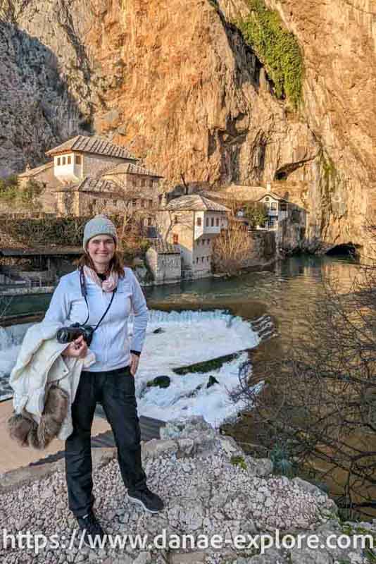 Moça em roupa de frio em frente a Blagaj Tekke - Dervish House - Bosnia Herzegovina - www.danae-explore.com