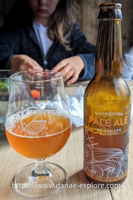 Copo e garrafa de cerveja Geiranger, em restaurante no Geiranger Fiorde, Noruega.