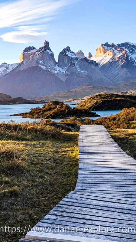 Passarela de madeira em paisagem com lago e picos nevados, Torres del Paine, Chile