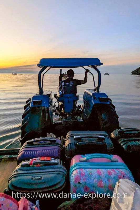 tractor takes trailer with hand luggage to beach at high tide