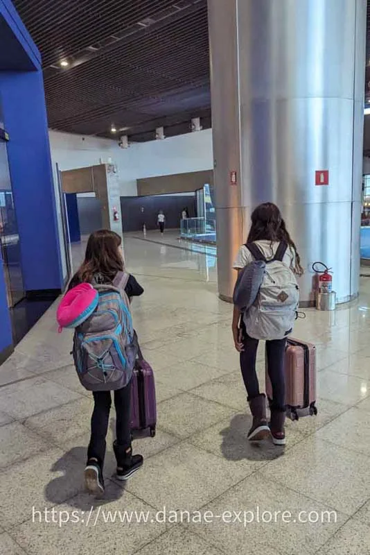 two children with hand luggage and backpack at airport
