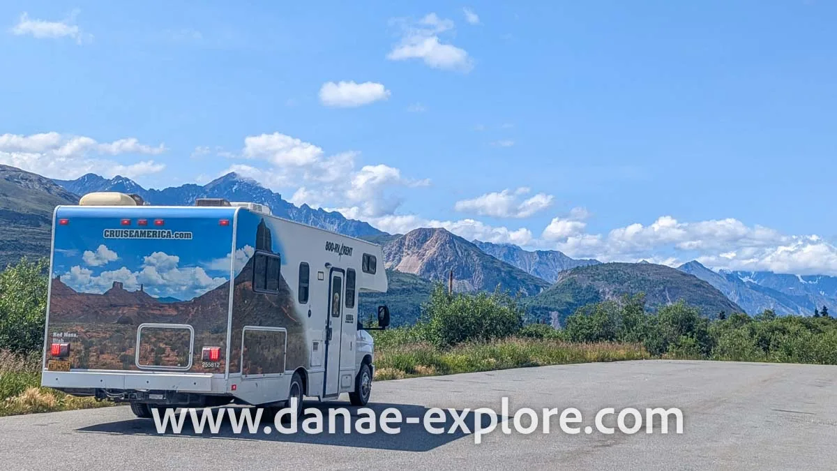 motorhome stopped on a road in the United States, in the background you can see a landscape with mountains and valleys, and some clouds