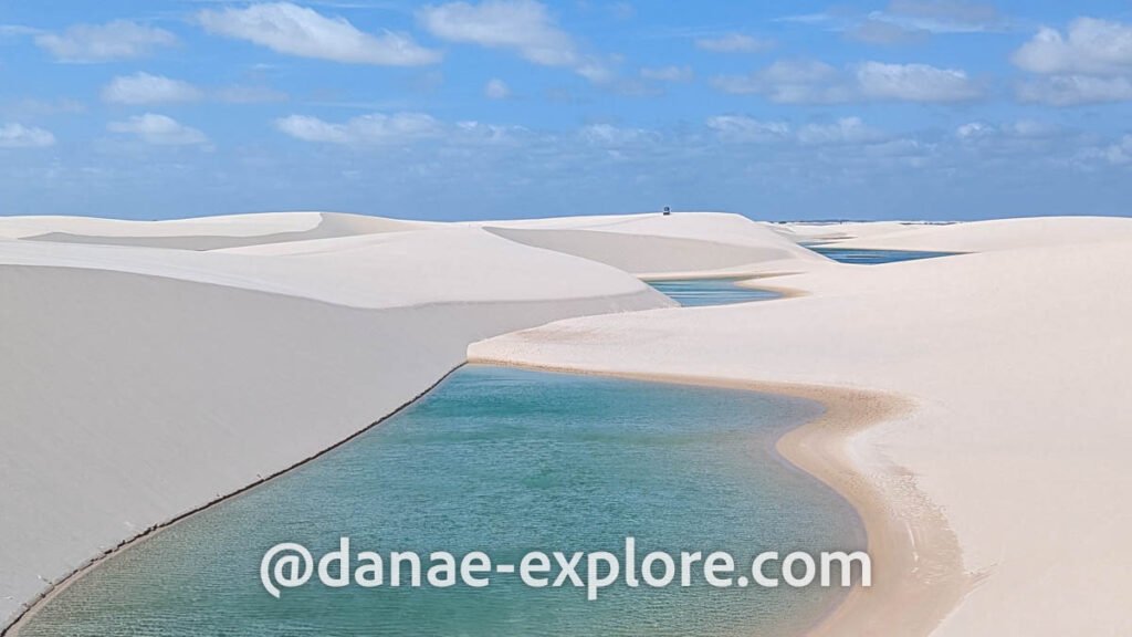 Sand dunes and turquoise lagoons in Lençóis Maranhenses on a sunny day with few clouds

