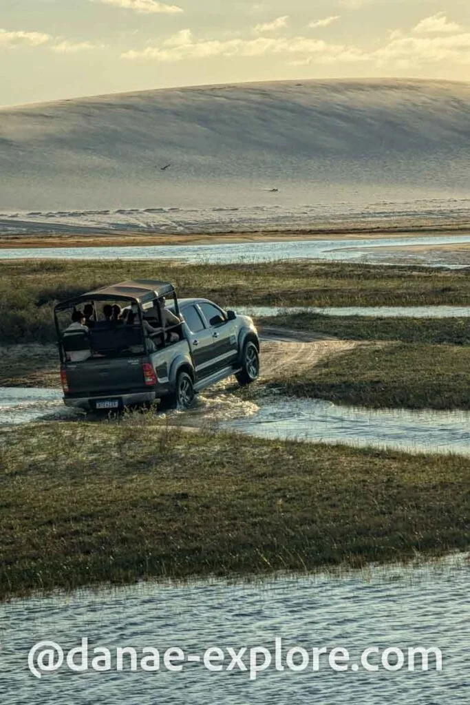 carro 4x4 que faz passeios em Lençóis Maranhenses passando por trecho alagado das dunas 
