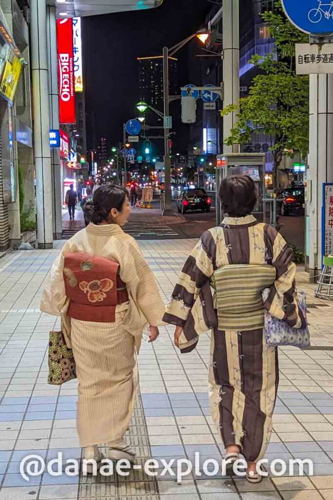 duas pessoas em trajes tradicionais japoneses andando pela calçada em Hiroshima