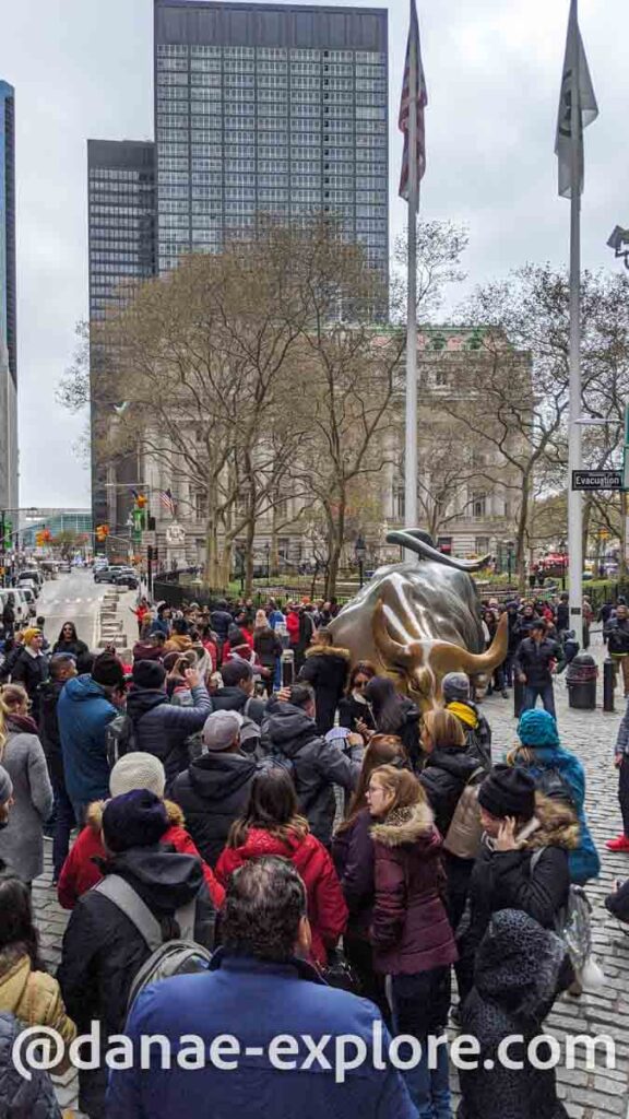 fila de pessoas para tirar foto no touro de Wall Street, em um dia de inverno nublado em Nova Iorque