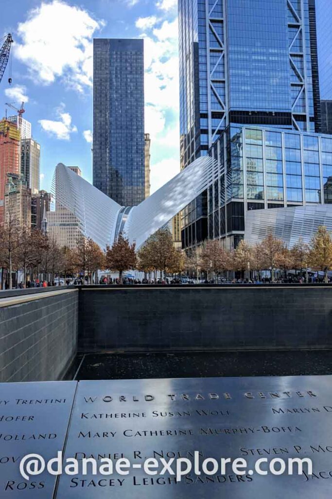 9/11 Memorial, ao fundo Oculus, em Nova Iorque, em dia de sol com algumas nuvens