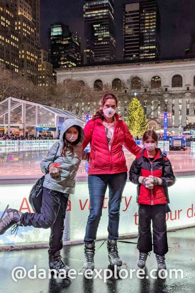 mãe e duas filhas na patinação no gelo do Bryant Park