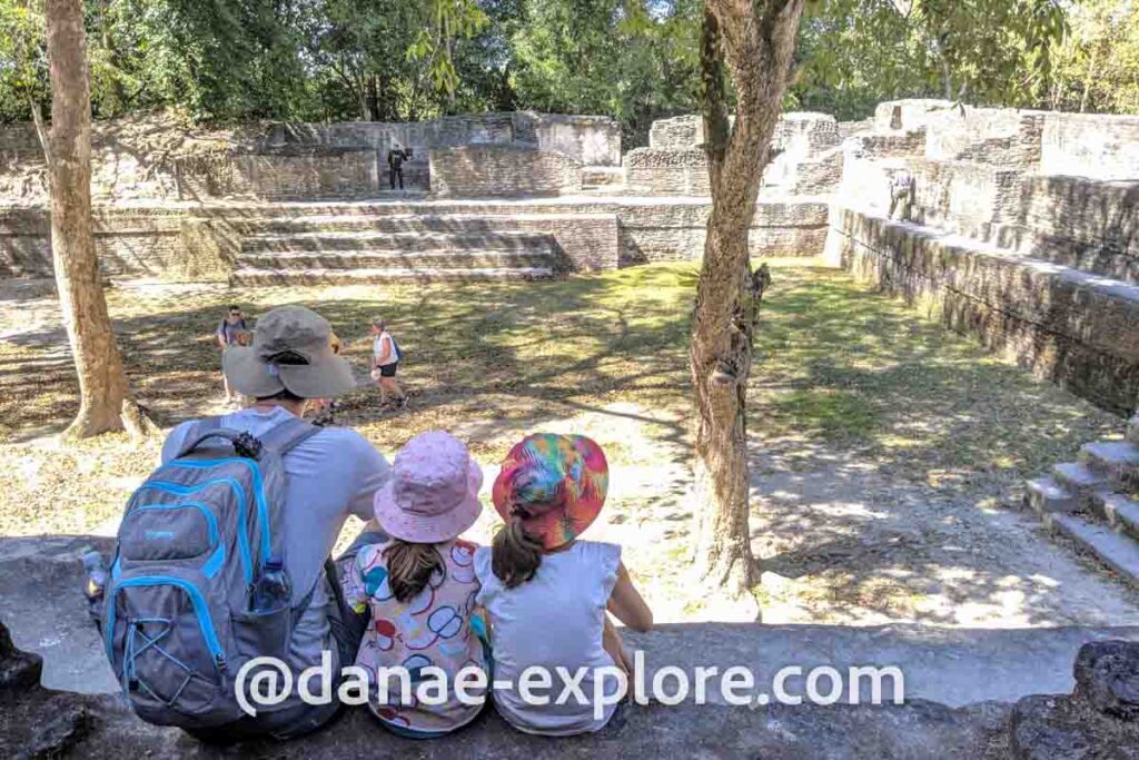 Pai e duas crianças, sentados nas ruínas maias de Cahal Pech, em Belize