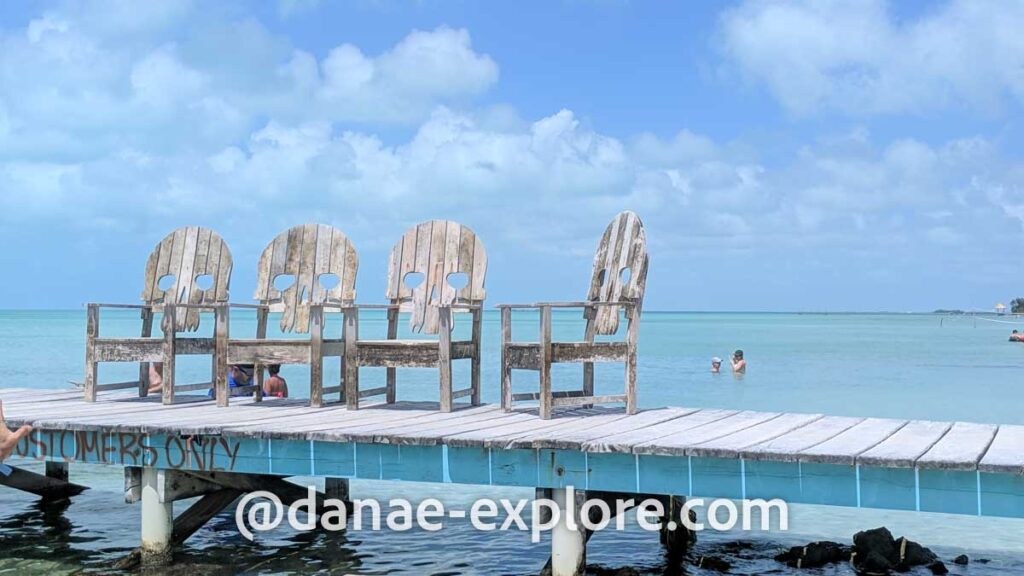 cadeiras de madeira com encosto em forma de caveira, em pier na praia Secret Beach, em Belize