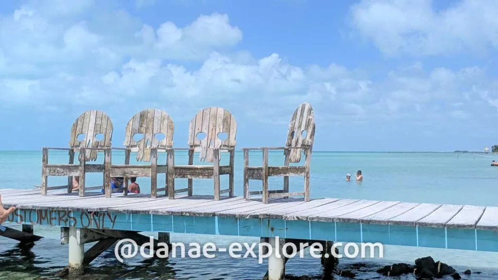 wooden chairs with skull-shaped backrests on a pier at Secret Beach in Belize