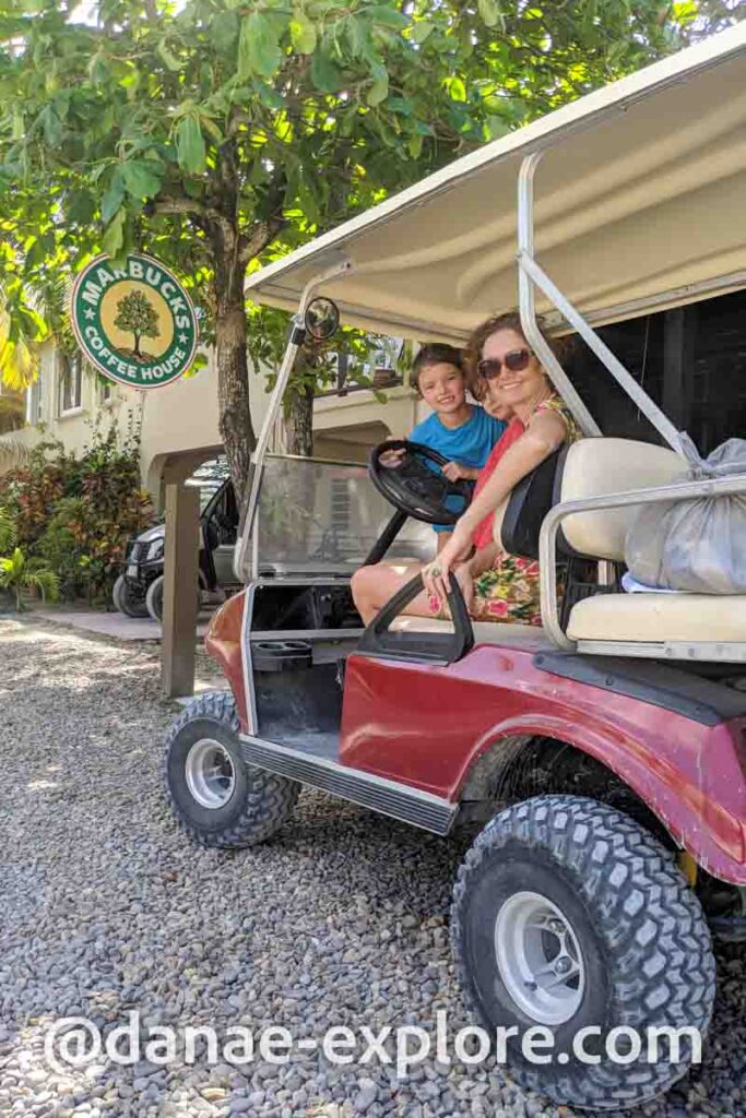 mãe e filha em carrinho de golfe alugado em Caye Ambergris