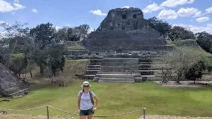 Turista em frente à pirâmide maia de Xunantunich, uma das principais ruínas arqueológicas para visitar em Belize – parte de nosso roteiro de uma semana no país