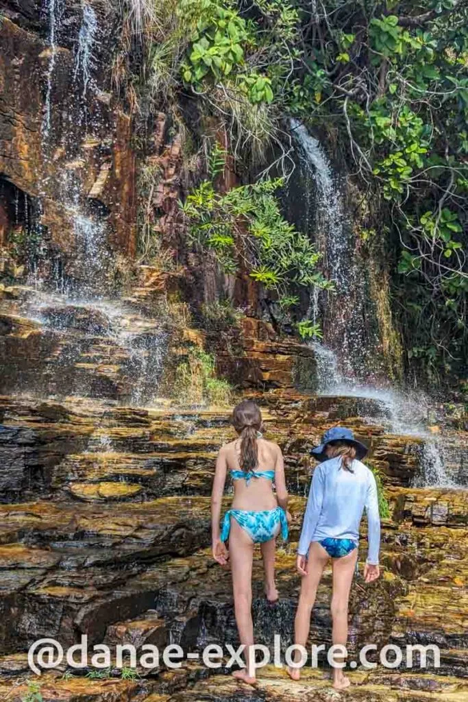 duas meninas sobem em pedras em direção a Cachoeira dos Dragões, em Pirenopolis