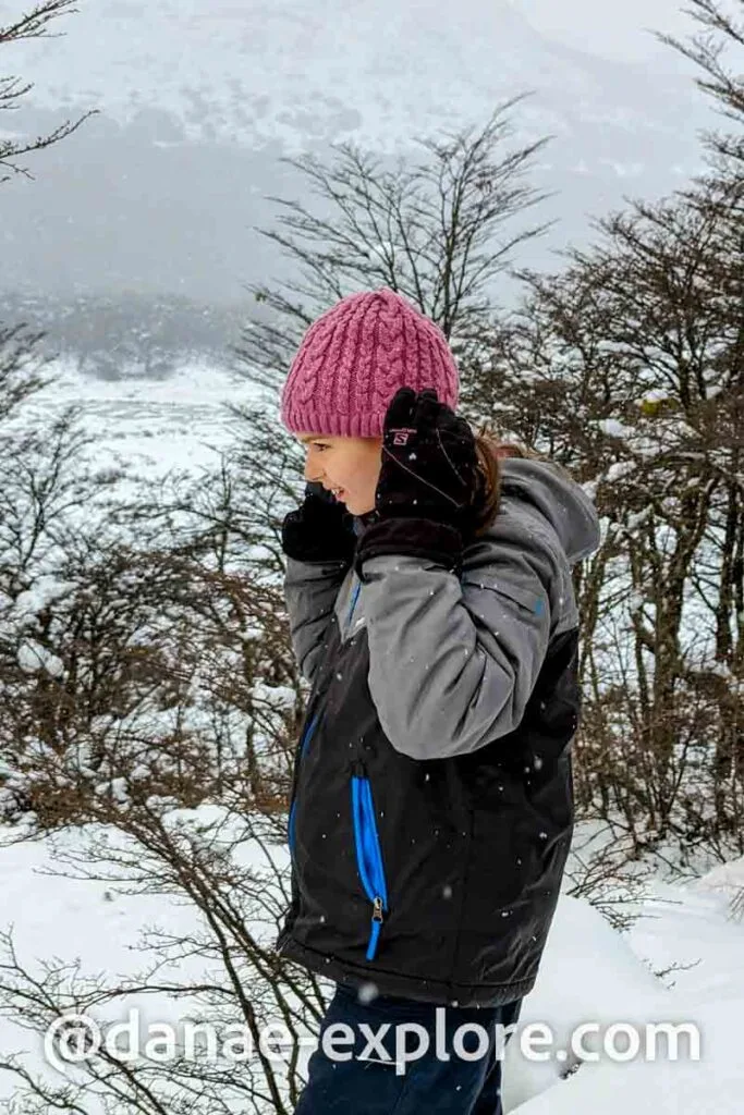 child walking while it snows in Ushuaia, in the middle of autumn