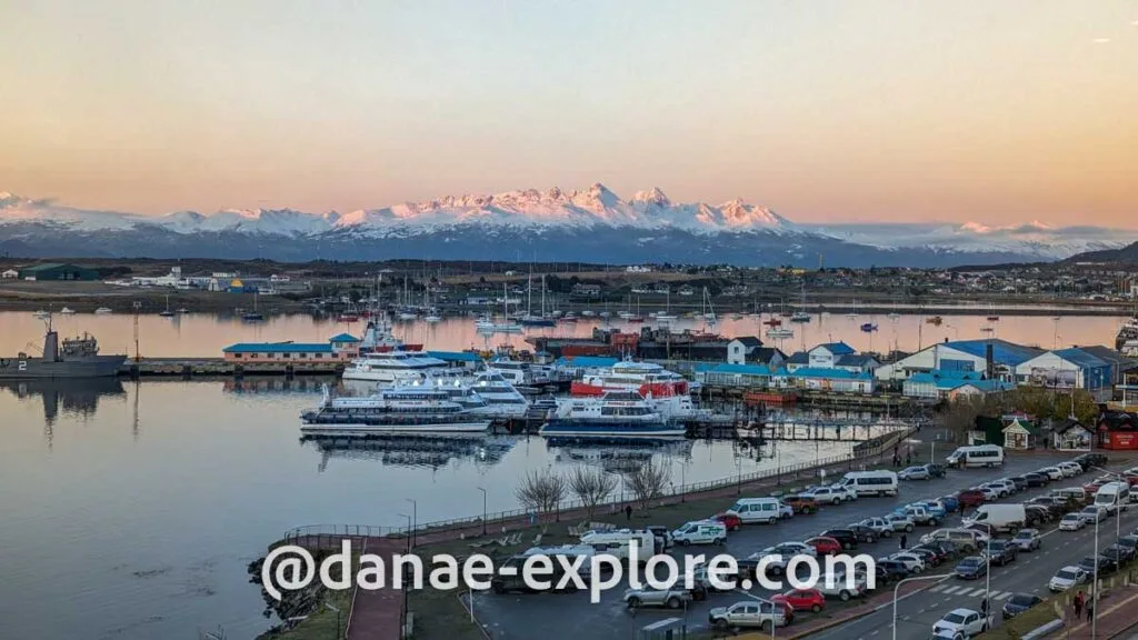 View from our apartment in Ushuaia: you can see a street with parked cars, the city port and snow-capped mountains in the background. 