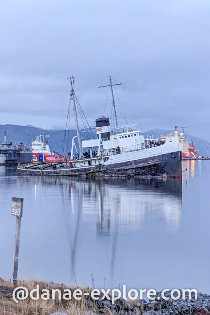 Shipwreck off the coast of Ushuaia, near the city's port. It's a cloudy day.