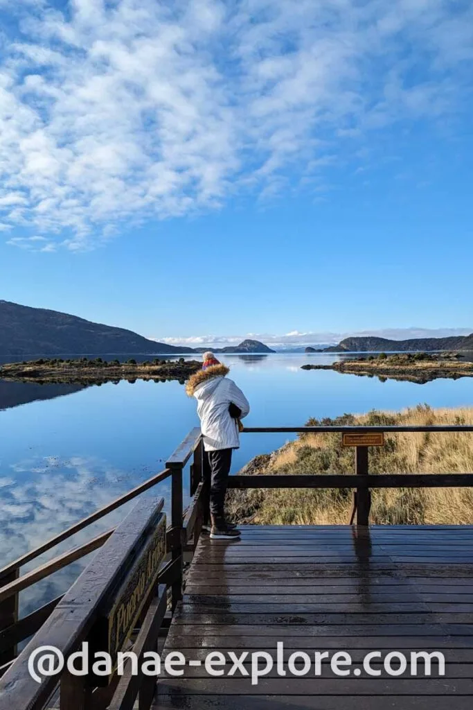 Girl in white coat and hat looks at landscape in Tierra del Fuego National Park, Argentina