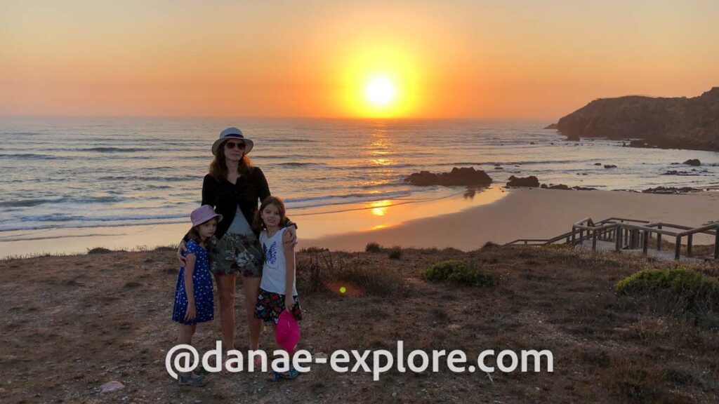 Mãe e duas filhas na praia ao por-do-sol