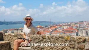 Turista no alto do Castelo de São Jorge, com Lisboa ao fundo — destaque em um roteiro Portugal cheio de história e paisagens.