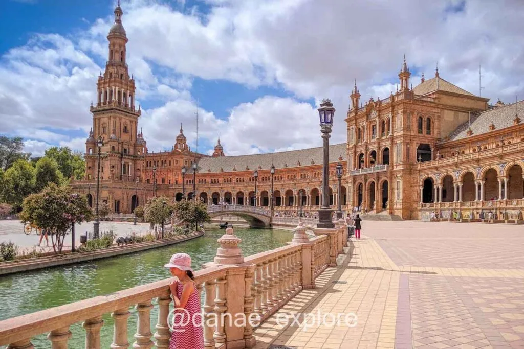 girl in Plaza de España, in Seville, on a sunny and hot day, with some clouds.