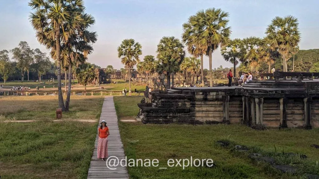 girl in long skirt and orange t-shirt in the gardens of Angkor Wat temple, Cambodia