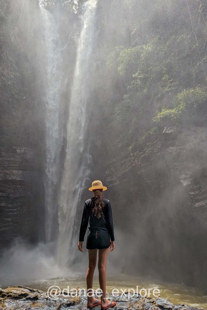Moça de costas para câmera, em frente a Cachoeira de Santa Bárbara