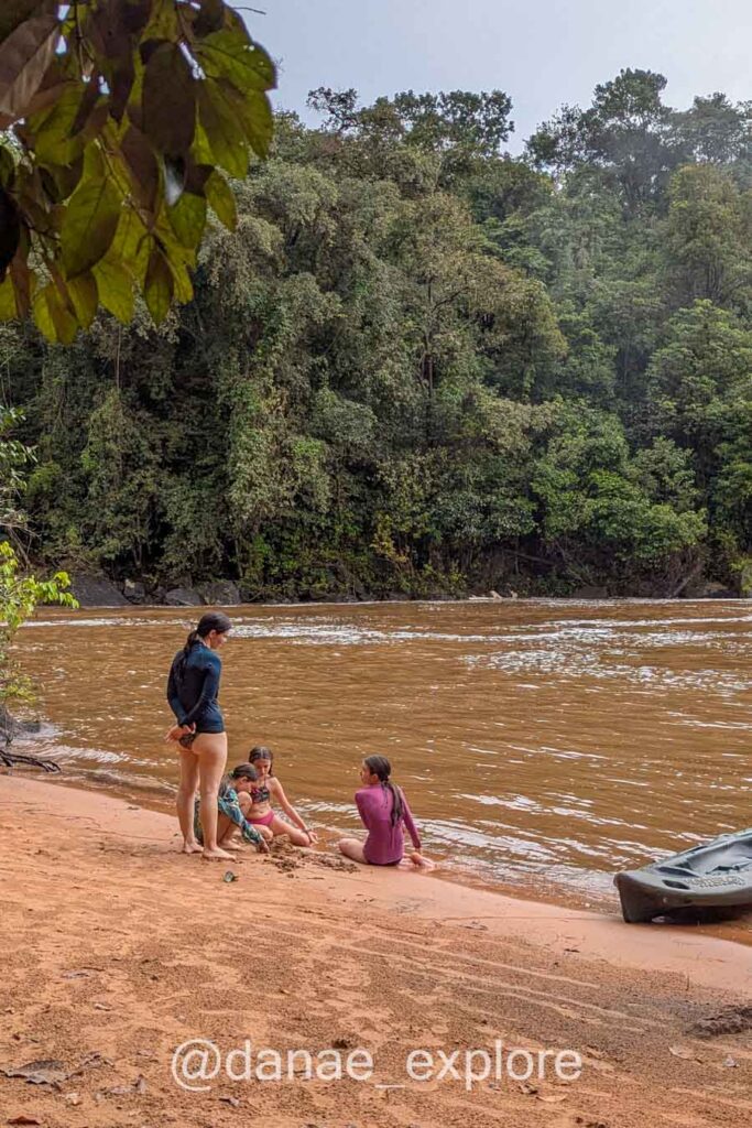 Crianças brincam na areia às margens do Rio Farinha, enquanto uma adulta as observa, no Parque Nacional da Chapada das Mesas, Maranhão