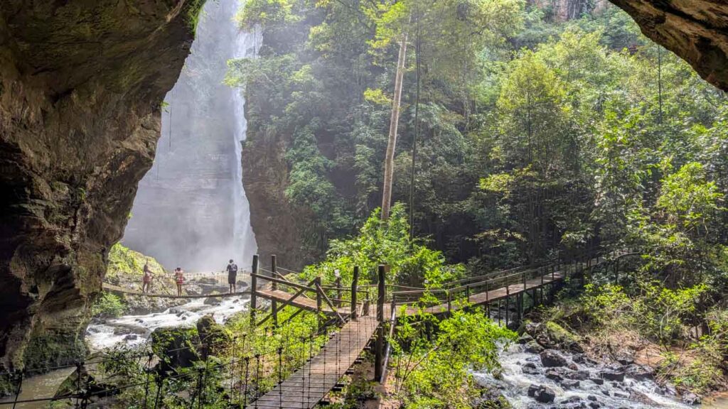 Passarela de madeira leva a uma cachoeira cercada por mata densa, atração imperdível em um roteiro Chapada das Mesas