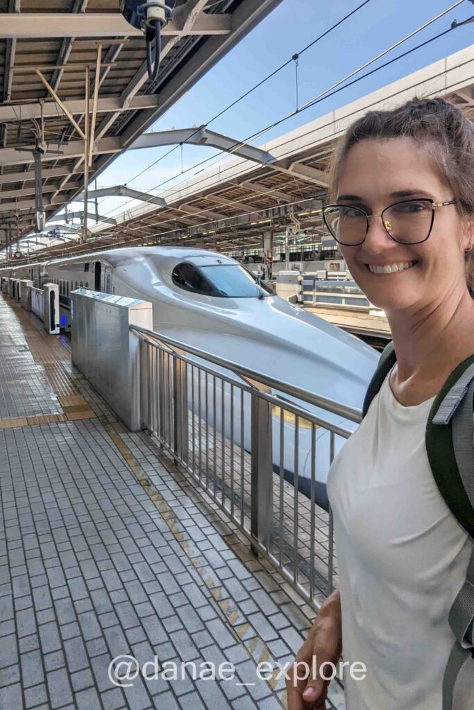 eu olhando para câmera em selfie com o Shinkansen, no Japão - quando for ao Japão, não deixe de viajar ao menos uma vez no trem-bala