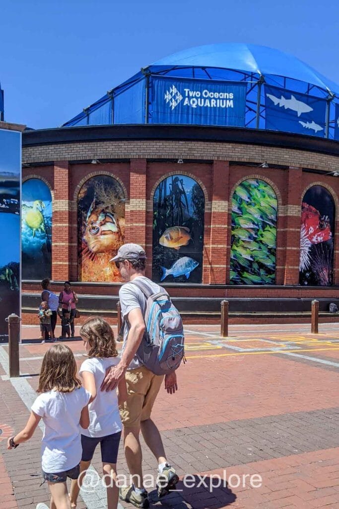 Father and two daughters entering the Tow Oceans Aquarium, part of our Cape Town itinerary