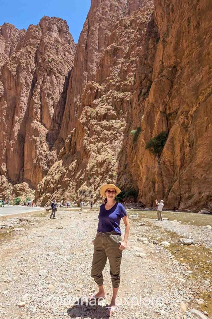 Moça em calça e camiseta, no Canion de Todra, em Marrocos