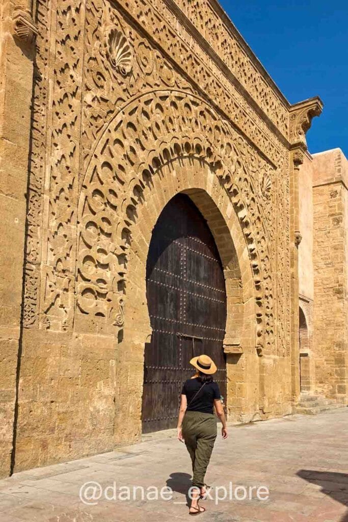 Me, wearing cargo pants, a black T-shirt, and a hat, walking through the Kasbah of the Udayas in Rabat