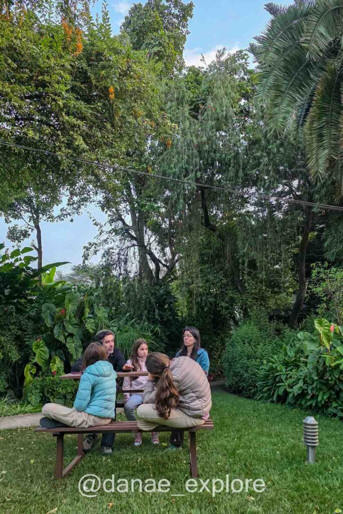 cinco pessoas sentadas a mesa em jardim do hotel Karibu Heritage House, em Arusha