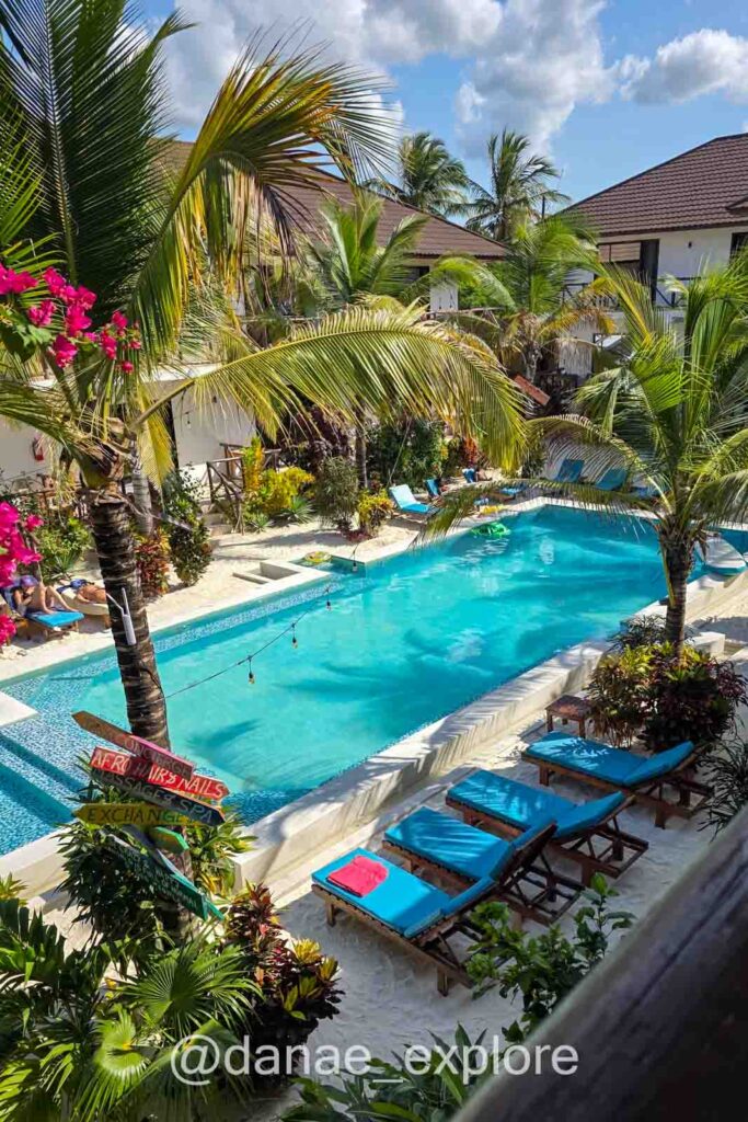 Piscina do hotel em que ficamos em Bwejuu / Paje, Zanzibar. É possível ver algumas palmeiras, cadeiras e parte dos quartos ao redor da piscina