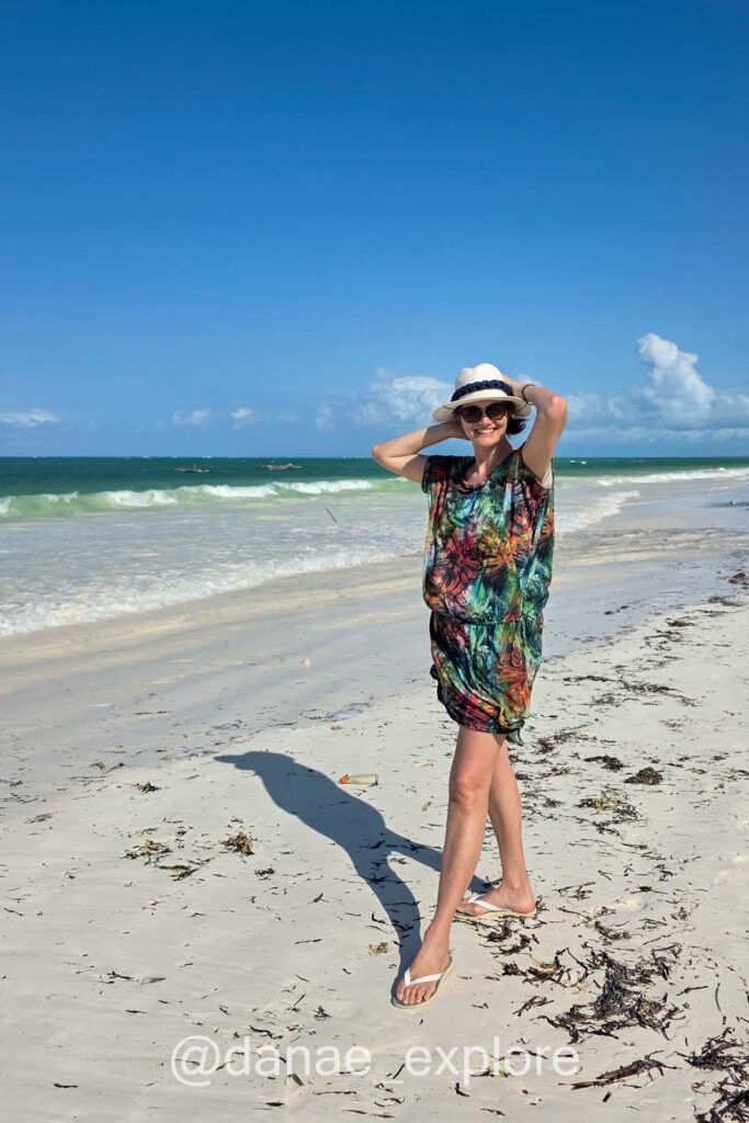 mulher em vestido colorido e chapéu na praia de Paje, parete de nossa sugestão do que fazer em Zanzibar