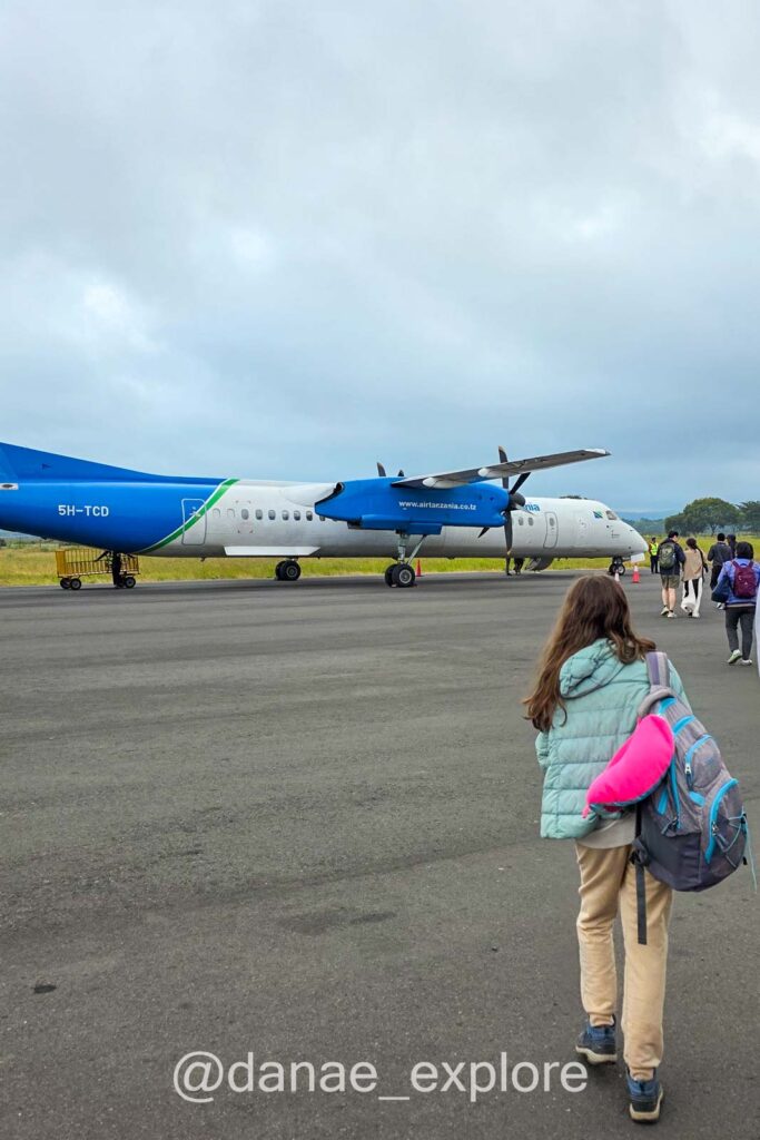 garota a caminho de embarcar no avião turbooélice da Air Tanzania que nos levou de Arusha a Zanzibar