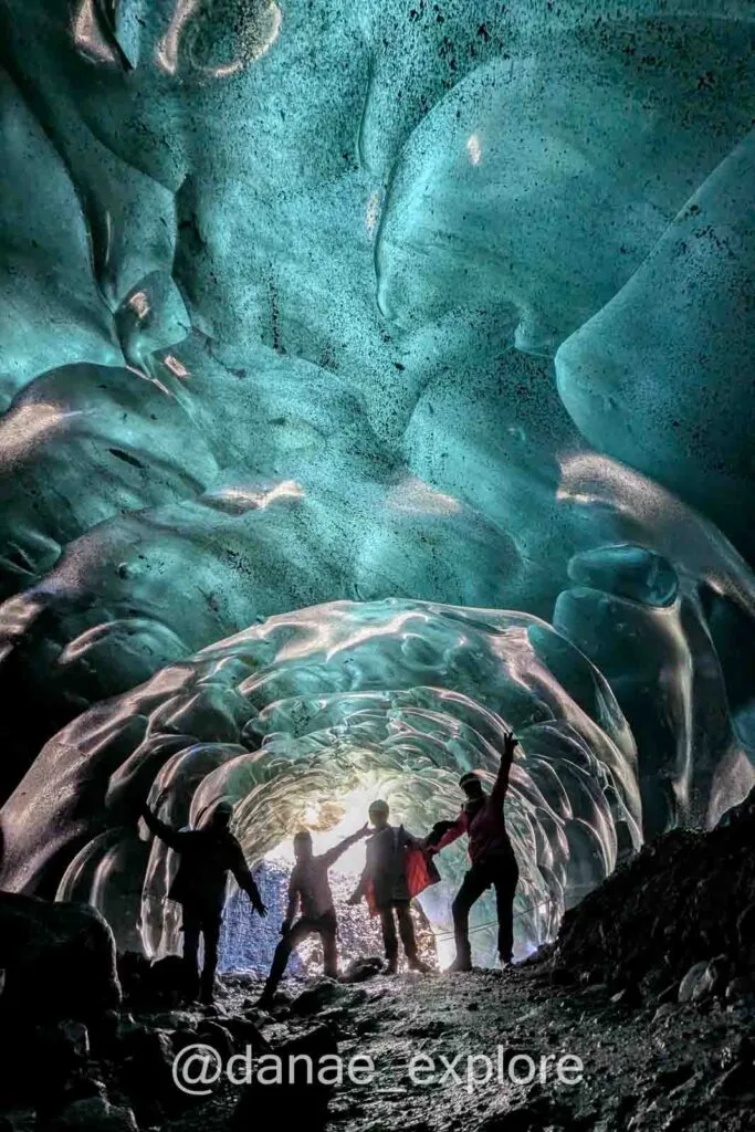 The four of us exploring the ice cave with light streaming in through the exit, creating silhouettes – one of the most idyllic walks I did in Iceland.