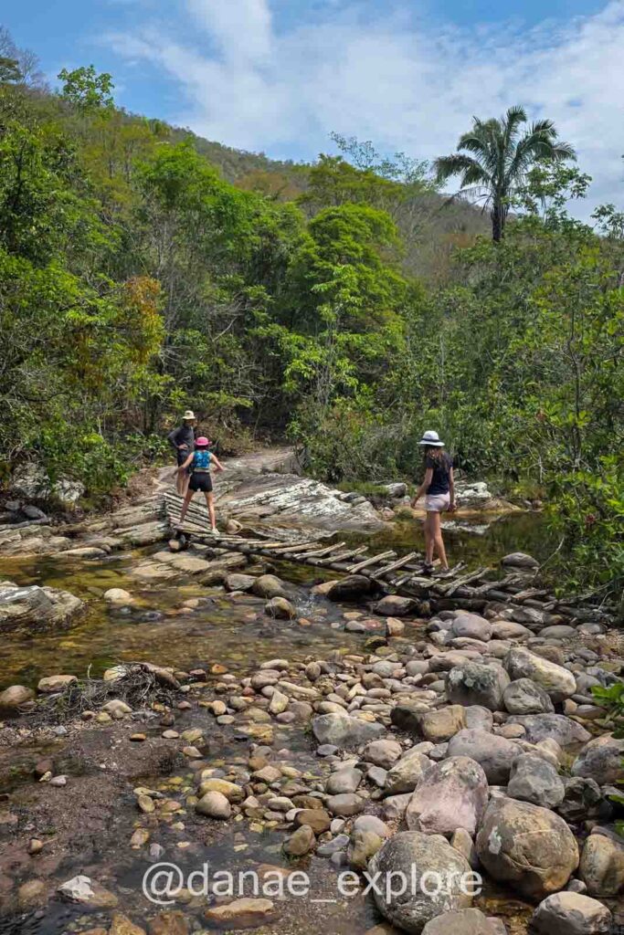 minhas duas filhas atravessando ponte de madeira bem precária sobre riacho na trilha para Cachoeira dos Anjos e Arcanjos.