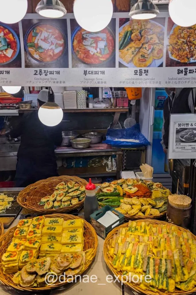 Street food em mercado coreano com pratos típicos como jeon e preparos à vista